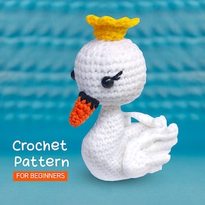Pode incluir: Padrão de crochê para iniciantes. Cisne de crochê branco com bico laranja e coroa amarela.