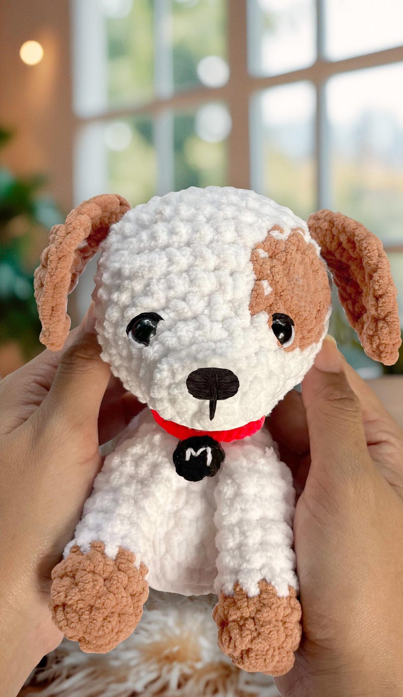 May include: A crocheted white and brown dog toy with a red collar and a black tag that says "M".