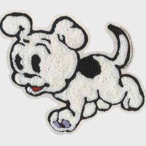 May include: A white and black cartoon dog patch with a textured, fluffy appearance. The dog has a black spot, black ears, and a red tongue. The patch is outlined in black and has a copyright notice.