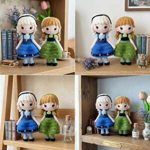 Peut inclure: Poup&eacute;es crochet&eacute;es repr&eacute;sentant deux personnages, l'un en robe bleue et l'autre en robe verte. Les poup&eacute;es ont des cheveux en fil et sont pos&eacute;es sur une &eacute;tag&egrave;re en bois. Elles font partie de la "Collection The Sisters of Arendelle".