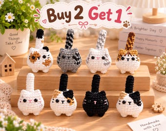 May include: Eight small, round, crocheted cat figurines with upright tails, black bead eyes, and embroidered mouths. The cats feature various color patterns including solid black, white, gray, calico, and tabby, arranged on a wooden display stand.