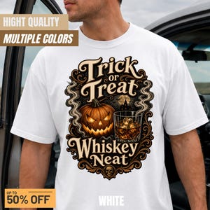 Peut inclure: Un t-shirt blanc avec une impression graphique portant le texte Trick or Treat Whiskey Neat. Le motif comprend une citrouille illuminée, un verre de whisky avec des glaçons, de la fumée tourbillonnante et la silhouette d'une maison hantée.