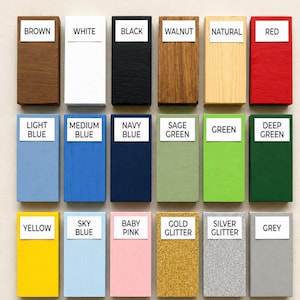 K&ouml;nnte beinhalten: Eine Farbpalette f&uuml;r individuelle Holzschilder mit achtzehn rechteckigen Farbmustern, die mit ihren jeweiligen Farben beschriftet sind, darunter Braun, Wei&szlig;, Schwarz, Walnuss, Natur, Rot, Hellblau, Mittelblau, Marineblau, Salbeigr&uuml;n, Gr&uuml;n, Dunkelgr&uuml;n, Gelb, Himmelblau, Babyrosa, Goldglitter, Silberglitter und Grau.
