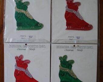 May include: Four Christmas-themed iron-on patches featuring a green and red ice skate with a gold trim. The patches are packaged in clear plastic bags with the text "EUROPA IMPORTS INC. Christmas Motifs" and the price and article number.