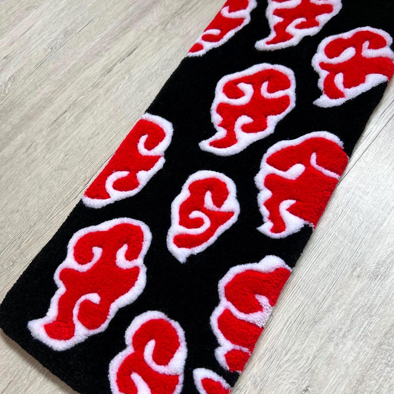 Hand-tufted anime keyboard rug with red cloud pattern on black background.