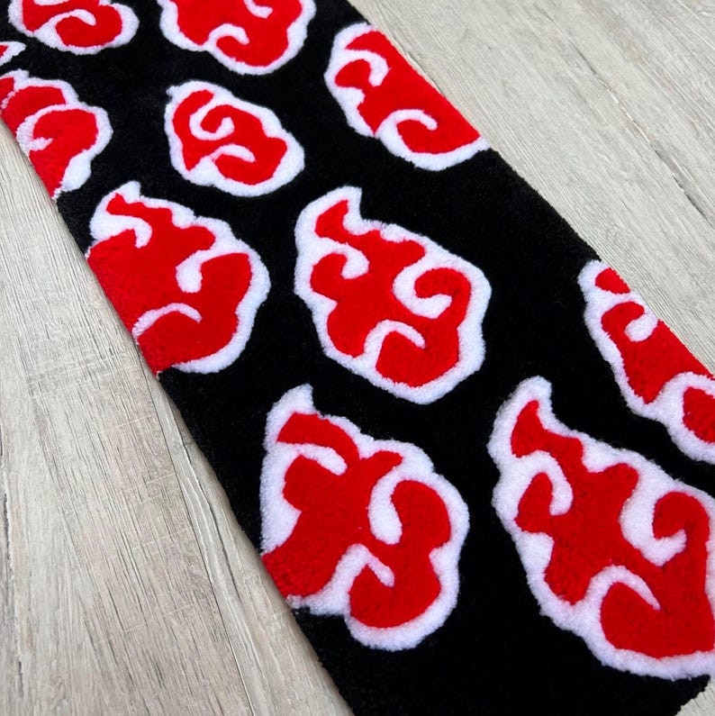 Hand-tufted anime keyboard rug with red cloud pattern on black background.