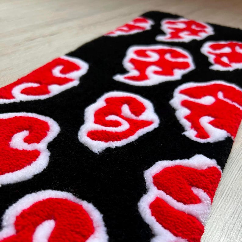 Hand-tufted anime keyboard rug with red cloud pattern on black background.
