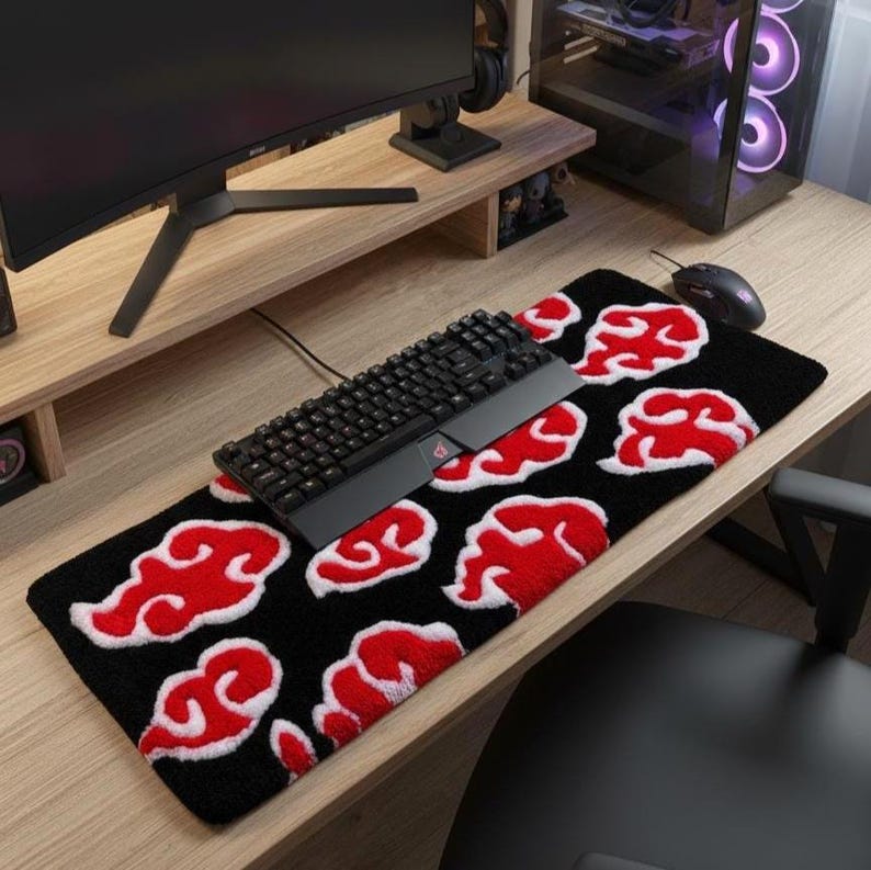 Hand-tufted anime keyboard rug with red cloud pattern on black background.