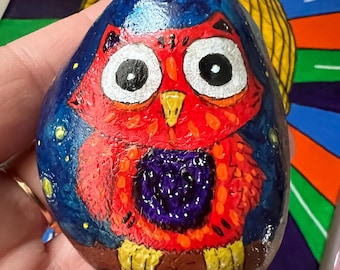 Búho rojo pintado a mano sobre roca: Arte animal en acrílico con un toque de fantasía.