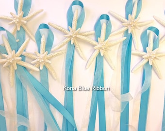 May include: A set of six white starfish tied with blue ribbon. The ribbon is a Kona Blue color. The starfish are tied to the ribbon with a knot. The ribbon is about 18 inches long.
