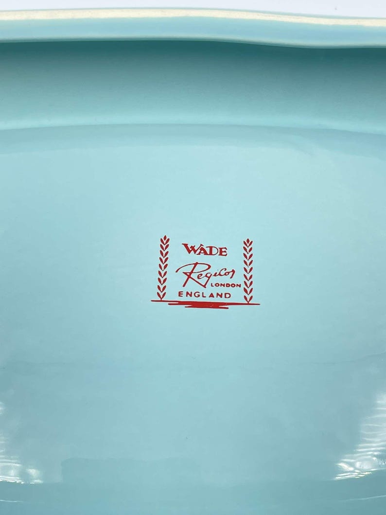 May include: A light blue ceramic bowl with a red Wade Regalo London England logo.