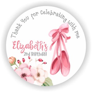 May include: Pink and white thank you favor sticker with the text "Thank you for celebrating with me Elizabeth's 2nd Birthday" and a pair of pink ballet shoes with a pink bow.