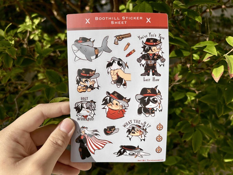 Pu&ograve; includere: Un foglio di adesivi con personaggi dei cartoni animati a tema western. Gli adesivi includono uno squalo, un cowboy, un cane e un lupo. Il testo sugli adesivi include "You've Yee'd Your Last Haw", "Holy", "Wubbaboo!" e "What the 17".