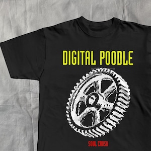 Peut inclure: T-shirt noir avec l'inscription "DIGITAL POODLE" en jaune au-dessus d'un engrenage blanc. En dessous, le texte "SOUL CRUSH" est en rouge. Le t-shirt est fait d'une matière douce.