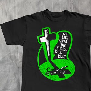 May include: Black t-shirt with a neon green graphic. The design features a cross, chains, and the text "MY LIFE WITH THE THRILL KILL KULT". The shirt is made of a soft material and is suitable for casual wear.