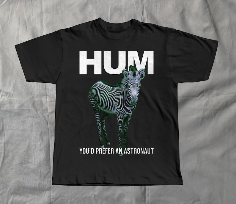 May include: Black t-shirt featuring a zebra illustration with the word "HUM" in white block letters above the zebra. Below the zebra, the text reads "YOU'D PREFER AN ASTRONAUT".