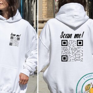 May include: White unisex hoodie with a black QR code and the text "Scan me!" printed on the front and back.