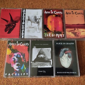 Puede incluir: Una colección de siete cintas de casete de Alice in Chains. Las portadas de los álbumes presentan varios diseños, incluyendo un cráneo de dinosaurio, un perro, un tarro con una cara y arte abstracto. Los títulos incluyen "Facelift" y "Jar of Flies".