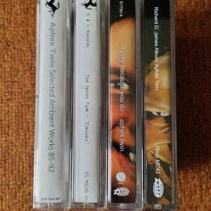 May include: Four cassette tapes with white and black labels. The labels include the text "Aphex Twin Selected Ambient Works 85-92", "The Aphex Twin - "Classics", "...I care because you do - aphex twin", and "Richard D. James Album: Aphex Twin".