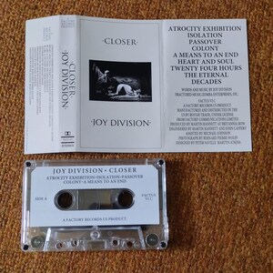 Puede incluir: Una cinta de casete del &aacute;lbum Closer de Joy Division. La cinta de casete es de pl&aacute;stico transparente con una etiqueta blanca. La etiqueta tiene el t&iacute;tulo del &aacute;lbum, el nombre de la banda y la lista de canciones. La cinta de casete est&aacute; en una caja de pl&aacute;stico transparente con un inserto blanco. El inserto tiene el t&iacute;tulo del &aacute;lbum, el nombre de la banda y la lista de canciones. El inserto tambi&eacute;n tiene una foto de la banda.