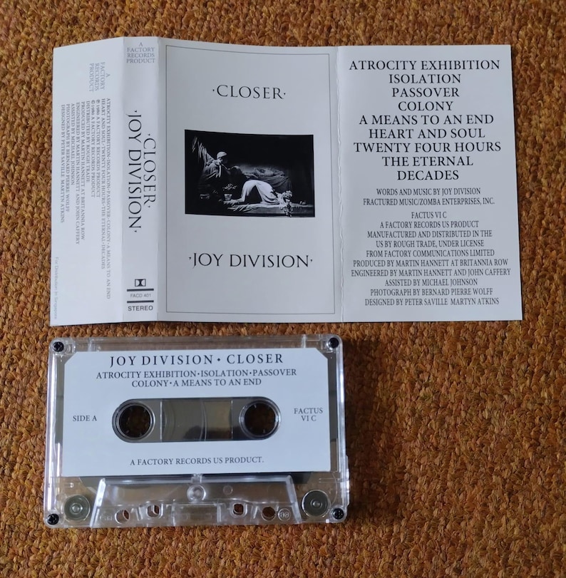 Puede incluir: Una cinta de casete del &aacute;lbum Closer de Joy Division. La cinta de casete es de pl&aacute;stico transparente con una etiqueta blanca. La etiqueta tiene el t&iacute;tulo del &aacute;lbum, el nombre de la banda y la lista de canciones. La cinta de casete est&aacute; en una caja de pl&aacute;stico transparente con un inserto blanco. El inserto tiene el t&iacute;tulo del &aacute;lbum, el nombre de la banda y la lista de canciones. El inserto tambi&eacute;n tiene una foto de la banda.
