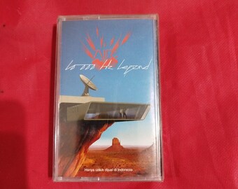 May include: A cassette tape with the album art for "10,000 Hz Legend" by AIR. The cover features a desert landscape with a structure and satellite dish. The text "AIR" and album title are visible. The text "Hanya untuk dijual di Indonesia" is also visible.