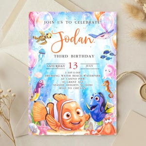 May include: A rectangular birthday invitation card featuring a watercolor underwater scene with a clownfish, blue tang, sea turtle, and jellyfish. The text reads: JOIN US TO CELEBRATE! Jodan THIRD BIRTHDAY SATURDAY 13 JULY 1:30P-6:00P BREAKING WATER BEACH WATERPARK.