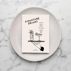 K&ouml;nnte beinhalten: Schwarz-wei&szlig;-Illustration einer Hand, die ein Tablett mit zwei Cocktails h&auml;lt. Die Cocktails sind mit "Mojito" und "Spicy Marg" beschriftet, wobei die Zutaten darunter aufgef&uuml;hrt sind. Der Text "Signature Drinks" befindet sich oben auf der Karte.