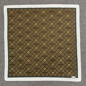 May include: A square, brown scarf with a repeating pattern of diamond shapes and the text "PAOLO GUCCI". The scarf has a white border with a dark green inner border. The pattern includes yellow and white diamond shapes.