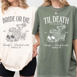 K&ouml;nnte beinhalten: Zwei T-Shirts, eines in Creme und eines in Olivgr&uuml;n, mit grafischen Designs. Das cremefarbene Shirt tr&auml;gt die Aufschrift "BRIDE OR DIE" &uuml;ber einer Illustration von Totenkopf, Rose und Cocktail. Das olivfarbene Shirt tr&auml;gt die Aufschrift "TIL DEATH do us party". Beide sagen "Emily's Bachelorette, Nashville, TN".