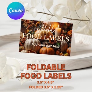 May include: A rectangular foldable food label card featuring a printed autumn scene with pumpkins, gourds, and a lit candle. The text reads editable FOOD LABELS and Add your own text. Dimensions are 3.5 inches by 4.5 inches flat, 3.5 inches by 2.25 inches folded.