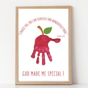 May include: Framed art print featuring a red handprint shaped like an apple with a green leaf and brown stem. The print includes the text "I praise you, for I am fearfully and wonderfully made." and "God made me special!"