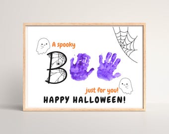May include: A framed Halloween-themed print with the word "BOO" spelled out. The "B" is decorated with a spiderweb design. Purple handprints replace the "OO". The print includes the phrases "A spooky" and "Happy Halloween!"