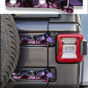 May include: A set of two metal hinge covers for a vehicle, featuring a printed graphic of palm tree silhouettes against a purple and blue sunset sky. The covers are shaped to fit over the rear door hinges of a dark grey SUV, with visible screw holes.