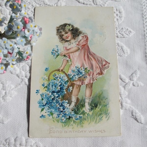Carte postale avec des voeux d'anniversaire pour une petite fille rose, une robe rose, des fleurs de myosotis, une ancienne carte romantique de style édouardien, datant de 1910