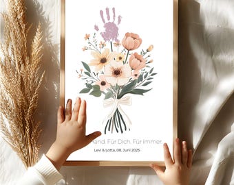 Könnte beinhalten: Ein gerahmter Blumendruck mit einem Strauß pfirsich- und cremefarbener Blumen und grünen Blättern, gebunden mit einem weißen Band. Ein violetter Handabdruck befindet sich über den Blumen. Der Text lautet: "Hand. Für Dich, Für immer. Levi & Lotta, 08. Juni 2025."