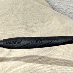 K&ouml;nnte beinhalten: Nahaufnahme eines schwarzen Objekts mit dem Text "MADE IN U.S.A." auf der Oberfl&auml;che. Das Objekt hat ein strukturiertes, geriffeltes Design f&uuml;r den Griff und scheint ein Griff oder Teil eines Werkzeugs zu sein.