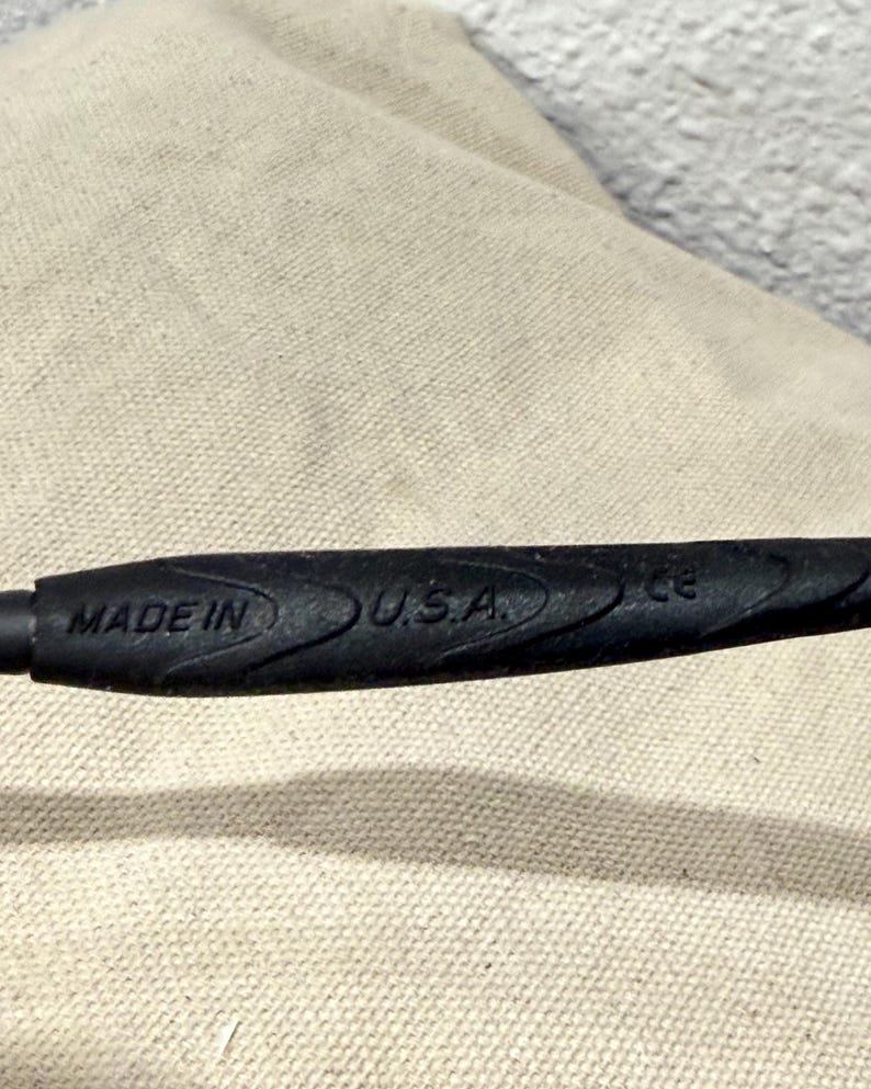 K&ouml;nnte beinhalten: Nahaufnahme eines schwarzen Objekts mit dem Text "MADE IN U.S.A." auf der Oberfl&auml;che. Das Objekt hat ein strukturiertes, geriffeltes Design f&uuml;r den Griff und scheint ein Griff oder Teil eines Werkzeugs zu sein.