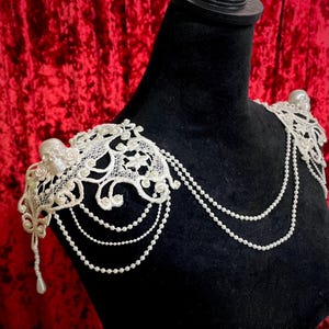 Hombreras de joyería con calavera en color blanco marfil con encaje de perlas bordado floral, accesorio hecho a mano, pieza de vestuario gótico barroco.