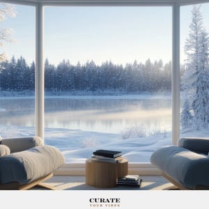 May include: Two grey upholstered armchairs face a large bay window overlooking a snow-covered landscape with a frozen lake and pine trees. A small cylindrical wooden side table sits between the chairs, holding a stack of books. Text reads CURATE YOUR VIBES.