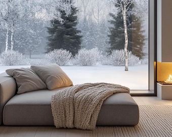 May include: A low-profile grey sofa featuring two matching square pillows and a thick, chunky knit beige throw blanket draped over the edge. The text CURATE YOUR VIBES is printed in black and beige at the bottom of the image.