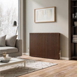 May include: A rectangular radiator cover featuring a series of vertical dark brown wooden slats. The cover has a flat top surface and is positioned against a light-colored wall, with white metal valves visible at the bottom on both sides.