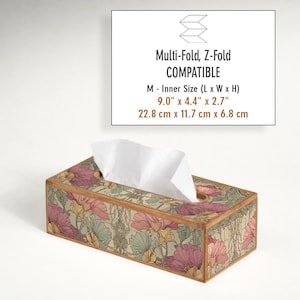 May include: Rectangular tissue box with a floral pattern in pink, green, and yellow. The box is made of wood and has a light brown border. The text on the image says "Multi-Fold, Z-Fold COMPATIBLE" and the inner size is 9.0" x 4.4" x 2.7".