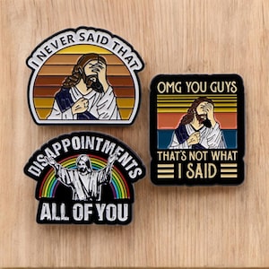 May include: Three black and white enamel pins with a retro design featuring a cartoon image of Jesus. The pins feature the text "I never said that", "OMG you guys that's not what I said", and "Disappointments all of you".