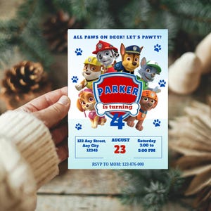May include: A light blue birthday invitation featuring cartoon characters from Paw Patrol. The invitation includes the text "ALL PAWS ON DECK! LET'S PAWTY!" and "PARKER is turning 4". Additional details include the date, time, and RSVP information.