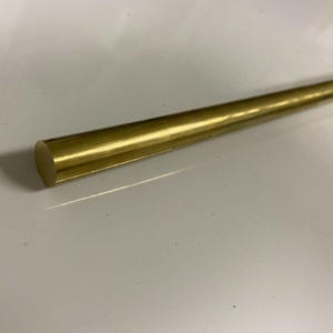 May include: A gold-colored metal rod with a rounded end.