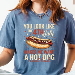 May include: A blue t-shirt with a graphic of a hot dog and the text "You look like the 4th of July makes me want a hot dog real bad".