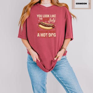 May include: A red t-shirt with a graphic of a hot dog and the text "You look like the 4th of July makes me want a hot dog".