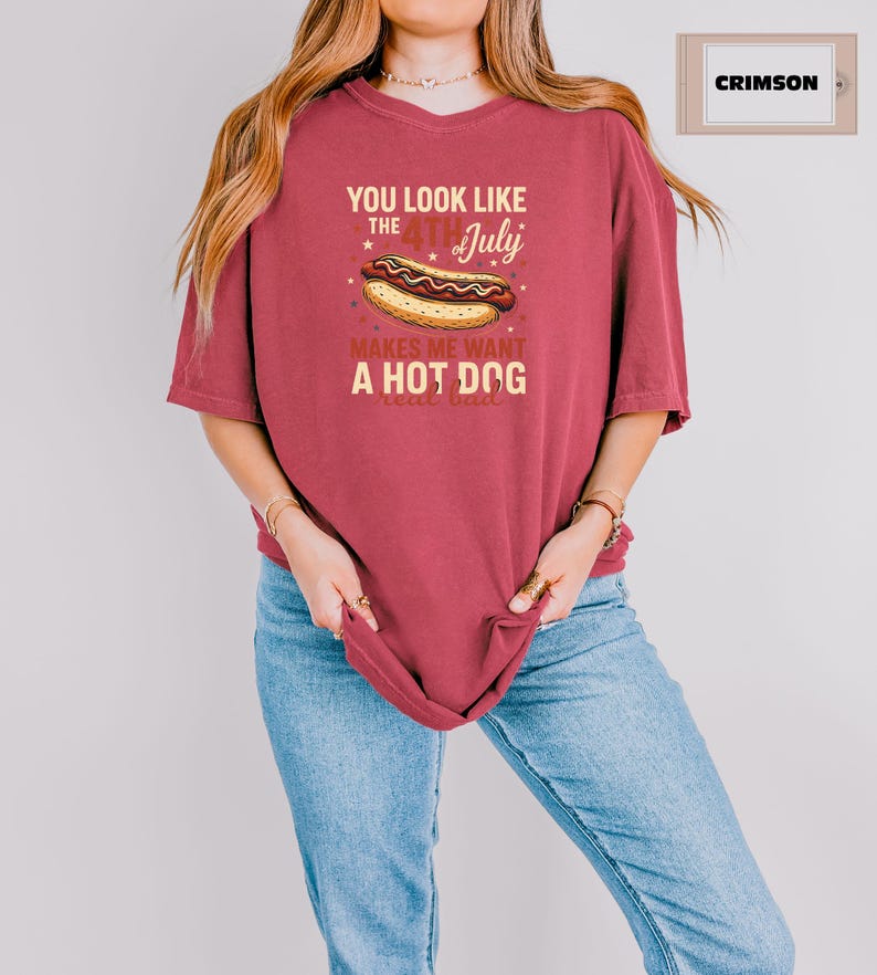 May include: A red t-shirt with a graphic of a hot dog and the text "You look like the 4th of July makes me want a hot dog".