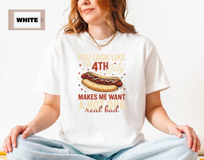 May include: White t-shirt with a red, white, and blue graphic of a hot dog and the text "You look like the 4th of July makes me want a hot dog real bad."